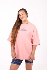 Remera oversize de algodón elastizado color rosa, con estampado gráfico en la espalda de estilo original.