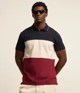Polo de hombre de corte regular, confeccionada en algodón, con cuello clásico, mangas cortas y diseño de bloques de color: azul marino en la parte superior, blanco en el centro y rojo borgoña en la parte inferior.