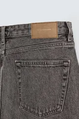 Pantalón de jean celeste de corte recto, con cinco bolsillos, efecto lavado y cierre frontal con botones.