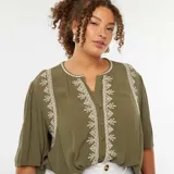 Blusa color verde oliva con bordados blancos en el frente y en el cuello, mangas 3/4 abullonadas y cierre frontal con botones.