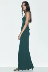 Vestido largo negro de escote fluido y tirantes finos ajustables.