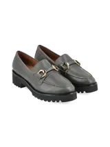 Mocasín gris de cuero con detalle de hebilla dorada y suela track negra.