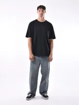 Remera gris de corte oversized, cuello redondo y mangas cortas. 