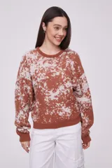 Sweater holgado con diseño estampado en tonos rosados y gris, de manga larga y cuello redondo.