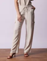 Pantalón cargo de lino color blanco, marca Marissa Olivia. Tiene pretina ancha elastizada con lazo de ajuste, bolsillos inclinados delanteros y bolsillos laterales con botón.