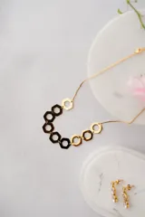 Collar dorado con cadena fina y colgantes de hexágonos calados.