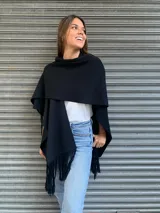 Ruana negra con apliques de cuero y flecos.