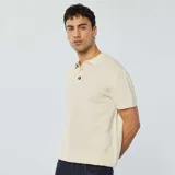 Remera polo de punto color crudo con cuello clásico, manga corta y cierre con botones de madera.