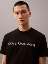 Remera negra de algodón con cuello redondo y logo "Calvin Klein Jeans" estampado en blanco en el frente.