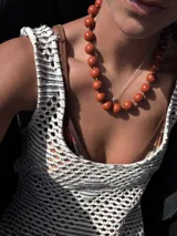 Collar de cuentas esféricas grandes, alternando colores turquesa y naranja quemado.