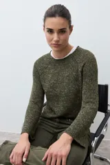 Sweater de tejido de punto color verde oliva jaspeado, con escote redondo y mangas largas con ligero acampanado en los puños.