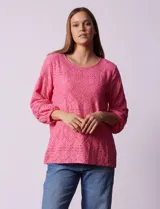 Blusa de broderie color blanco, de mangas largas con puños elásticos.