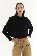 Sweater de manga larga en color negro, con diseño de punto y corte corto.