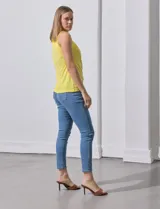 Blusa sin mangas color amarillo, con cuello redondo con frunces delanteros y abertura con botón en la espalda.