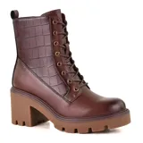Bota negra de cuero sintético con caña media, cordones frontales, detalle de textura simil cocodrilo en la parte superior, cierre lateral y suela track con taco ancho.