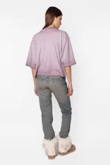 Remera de jersey color lila con efecto desgastado, corte Boxy fit, cuello alto en Rib al tono y manga corta. Estampa láser en el delantero.