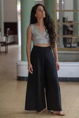 Pantalón palazzo negro de algodón con corte evasé, tiro alto, bolsillos laterales, elástico en la espalda y faja ancha.