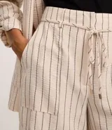 Short de cintura alta color crema con rayas verticales finas en azul marino, con bolsillos laterales y cintura elástica ajustable con lazo.