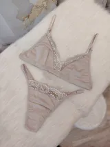 Conjunto de ropa interior color nude, compuesto por un corpiño triangular de algodón con detalles de encaje y una tanga a juego.