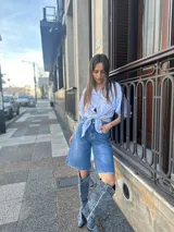Camisa celeste a rayas blancas con mangas abullonadas y nudo en la parte delantera.