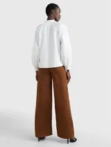 Camisa blanca de algodón orgánico con cuello inglés, corte amplio y mangas raglán abullonadas con puños abotonados.
