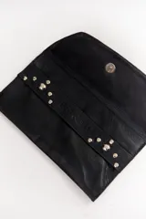 Sobre de cuero negro con diseño de tachas en zigzag y muñequera para mejor agarre.