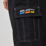 Short de baño negro con cintura elástica con logo de la marca Rusty en blanco.