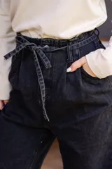 Pantalón de jean celeste de corte babucha con lazo ajustable en la cintura.