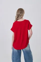 Blusa holgada de poliéster color blanco, con escote en V profundo y pinzas frontales que generan caída. Mangas cortas.