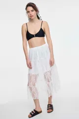 Top de bikini verde con breteles finos y detalle de aro metálico en el centro.