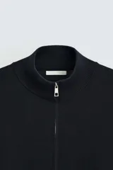 Cárdigan negro de punto con cuello perkins, cierre frontal con cremallera, manga larga y corte regular fit.