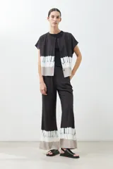 Pantalón de vestir negro con efecto tie dye en gris y blanco en el ruedo, corte palazzo.