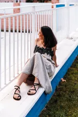 Sandalias negras de tiras finas, con suela plana y cierre con hebilla en el tobillo.