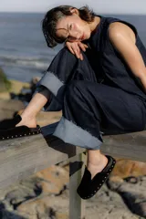 Zuecos de gamuza color marrón chocolate, con base de goma negra, tachas plateadas alrededor de la base y plantilla acolchada.