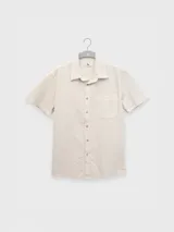 Camisa azul de manga corta confeccionada en algodón ligero con textura waffle. Presenta corte cuadrado, bolsillo en el pecho y botones de coco grabados con el logo de Polonio.