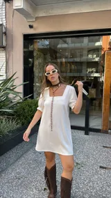 Vestido corto blanco de corte evasé, con escote cuadrado y mangas cortas abullonadas.