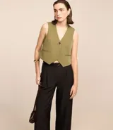 Pantalón wide leg negro de poliéster y elastano, con trabillas en la cintura, cinturón con hebilla y pliegues. Estilo sastrero.