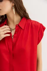 Camisa azul petróleo de viscosa y modal, manga corta, cuello camisero y frunces en los hombros.