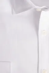 Camisa blanca de manga larga texturizada, tejida en dobby, con cuello italiano y cartera abotonada. Tiene un logo bordado en el pecho.