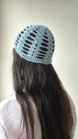 Gorro celeste de crochet con diseño calado.