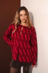 Cárdigan tejido con diseño de rombos rojos y negros, con mangas largas y cierre frontal con botones.