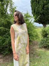 Vestido midi de corte evasé con estampado de hojas en tonos verdes y beige.