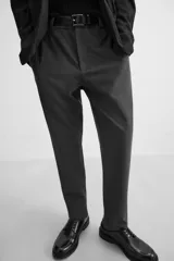 Pantalón slim fit negro confeccionado en tejido con elasticidad en ambas direcciones. Cuenta con bolsillos frontales y traseros de vivo con botón. Cierre frontal con cremallera y botón.