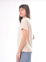 Remera color crudo con estampado de un pez rojo en el frente.