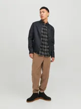 Campera negra de cuero sintético con cuello mao, cierre frontal con cremallera, bolsillos laterales y en el pecho con cremallera, mangas largas con detalle de costuras en los hombros.