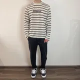 Pantalón jean negro de corte slouchy, con tiro alto y largo al tobillo.