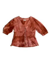 Camisa color ladrillo con estampado tie-dye, corte en la cintura y abotonadura central. Tiene manga 3/4 abullonada con detalle de elástico en puños.