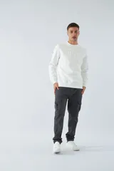 Pantalón cargo slim fit color gris oscuro, con cierre de botón y cremallera, trabillas para cinturón y bolsillos cargo con botones.