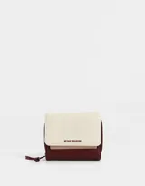 Billetera colorblock de cuerina con solapa con broche a presión, cierre y tirador.