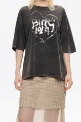 Camiseta de algodón negra con efecto gastado, corte oversize y mangas cortas anchas. Presenta un estampado frontal de un corazón dibujado con alambre de púas, conteniendo el texto "BIMBA LOLA" en su interior.